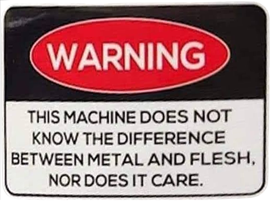 sign reading 'WARNING: THIS MACHINE DOES NOT KNOW THE DIFFERENCE BETWEEN METAL AND FLESH, NOR DOES IT CARE.'